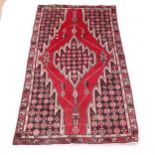 A red ground Afghan rug, 182cm x 107cm