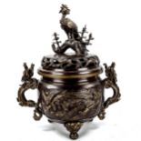 A large Chinese patinated bronze incense burner, with exotic bird finial, parcel gilt relief cast
