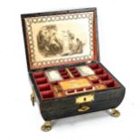 A Regency leather-covered sarcophagus-shaped sewing box, with brass mounts and lion paw feet,