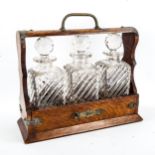 A Victorian oak 3-bottle tantalus, with electroplate mounts and 3 original decanters, length 34cm