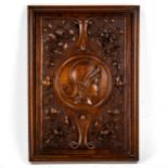 A fine relief carved walnut Classical wall plaque, with central panel depicting a Greek warrior,