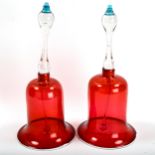 A large pair of Victorian cranberry and clear glass ornamental bells with white glass piped edges,