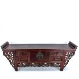 A Chinese stained wood altar table of small size, with 4 small carved drawers and central cupboard