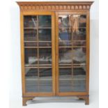 Mahogany bookcase, 19th Century, keyed and arcaded drop cornice over two glazed doors opening to