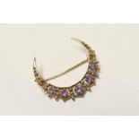 9ct gold amethyst crescent brooch, set with five small round cut stones in an openwork setting,