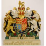 Royal Warrant coat of arms, painted and gilded plaster inscribed 'By Appointment To Her Majesty