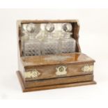 Late Victorian oak tantalus, circa 1890, having silver plated mounts with an inscribed