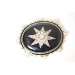 Victorian mourning brooch, circa 1880, centred with a star of split pearls against a black enamelled