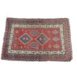 Caucasian woollen prayer rug, red field with two abrashed blue lozenge medallions, within a red,