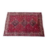 Bakhtiari woollen carpet, the red field with triple pole medallion in fawn and black, within a