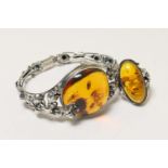 Baltic amber and silver bangle, having a large cognac coloured amber pebble, approx. 30mm