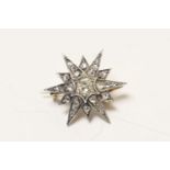 Victorian or Edwardian diamond star pendant brooch, centred with an old cushion cut diamond of