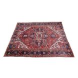 Persian Heriz carpet, crimson field centred with a fawn and salmon pink lozenge shaped medallion,