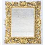 Florentine carved giltwood framed wall mirror, circa 1900, rectangular bevelled glass plate within a