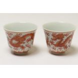 Pair of Chinese wine cups, each painted in iron red with two dragons chasing flaming pearls, Tongzhi