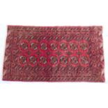 Traditional Bokhara woollen rug, red field with two rows of guls within a madder border, 180cm x