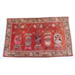 Mongolian Baotou woollen carpet, terracotta field with five flower vases in pinks and greens, within