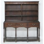 George III oak dresser and plate rack, circa 1760-80, the boarded back with two shelves over a