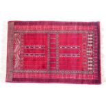 Quality Tekkhe woollen rug, deep red field within a geometric border, 192cm x 125cm