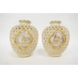 Matched pair of Royal Worcester double walled reticulated vases by George Owen, each of ovoid form