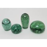 Four Nailsea glass dumps, 19th Century, comprising a bun form with random air bubbles to the centre,