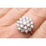 Diamond cluster ring, set with 19 round brilliant cut stones, in a flowerhead stepped 18ct white
