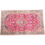 Kashan woollen rug, having a deep red field dispersed with palmettes, size 180cm x 106cm
