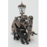 Indian carved ebony ceremonial elephant, worked with a silver howdah, set with coloured stones,
