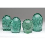 Four Nailsea glass dumps, each encasing a bubble fountain encased in green glass, the largest