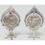 Two Chinese silver small table censers, each worked with dragons within a ring of fire, raised on