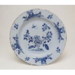 English delft blue and white charger, circa 1740, decorated after the Chinese with a central peony
