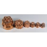 Six Copper Jelly Moulds, Victorian, one by Benham & Froud, No. 510, moulded with six buttresses,