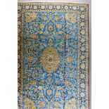 A Fine Qum Carpet, Late 19th/Early 20th Century, woven in blue and fawn, with a bold central