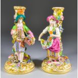 A Pair of English Porcelain Figural Pillar Candlesticks, Early 19th Century, the whole encrusted