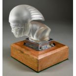 A Red Ashay Glass Car Mascot - Racing Driver, Circa 1930, 5ins high, mounted on wooden plinth