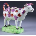 A Sunderland Lustre Cow Creamer and Cover, 19th Century, standing on a naturalistically modelled