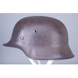 A World War II German Helmet, unpainted but patinated