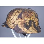 A German World War II Helmet, painted in camouflage pattern, with chicken wire attached to