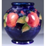 A Moorcroft Pottery Bulbous Vase, decorated in colours with "Pomegranate" pattern on a dark blue