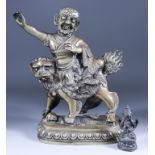 A Tibetan Bronze Figural Group, 20th Century, of a deity riding a Dog of Fo, trampling a prostrate