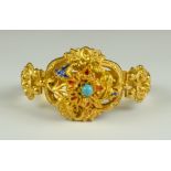 A Gem Set Gold Baroque Style Bracelet, yellow metal set with a centre turquoise stone, decorated