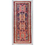 A Kazak Long Rug, Early to Mid 20th Century, woven in colours with four hooked lozenge shaped