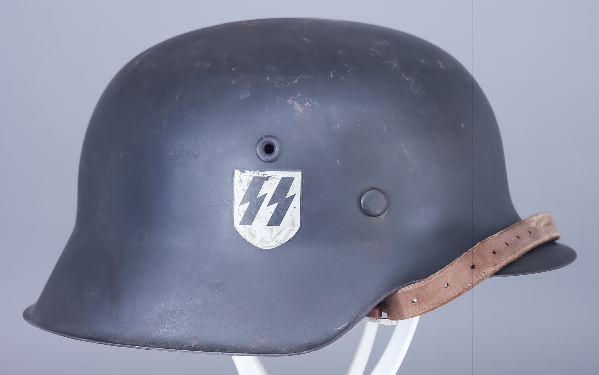 A German World War II Helmet, painted black, with SS decal to one side Provenance: Tennents