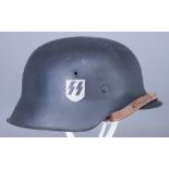 A German World War II Helmet, painted black, with SS decal to one side Provenance: Tennents