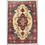 A Sarouk Rug, Early 20th Century, woven in colours of wine, navy blue and fawn with a central floral