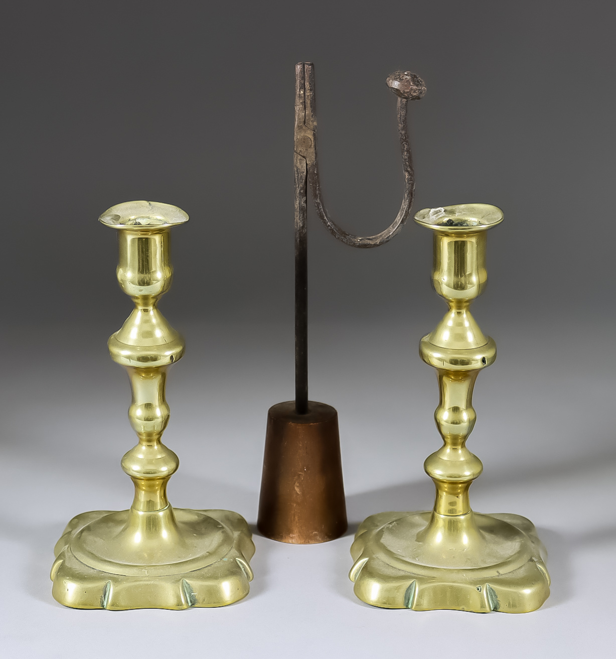 A Pair of English Brass Candlesticks, Mid 18th Century, 7.25ins high, and a wrought iron rush nip on