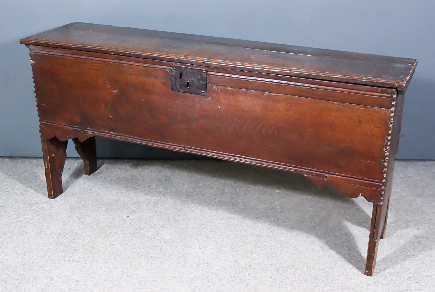 A 17th Century Oak Plank Coffer, with moulded front edge to top, on shaped end supports, 57.25ins