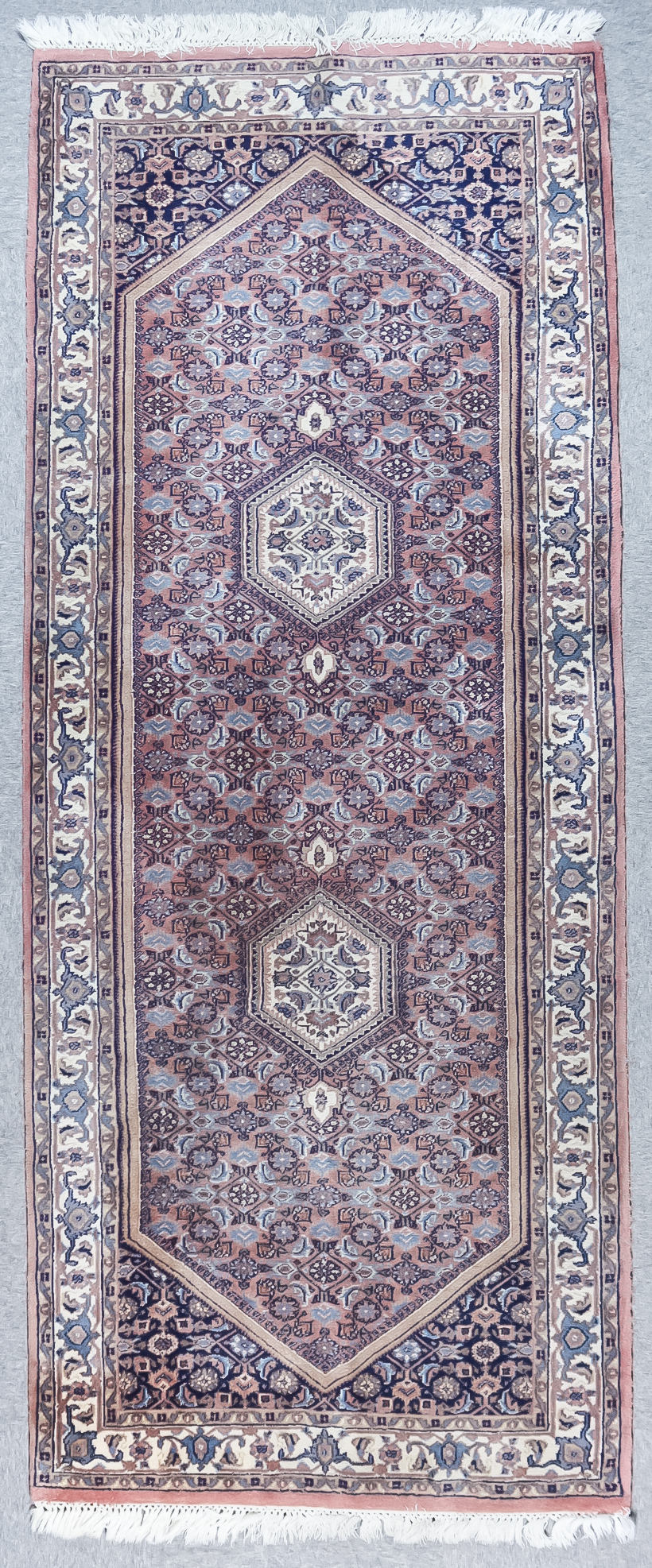 A Tabriz Runner, Mid 20th Century, woven in rose, ivory and blue, with twin stepped hexagonal