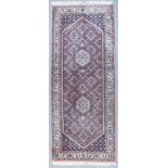 A Tabriz Runner, Mid 20th Century, woven in rose, ivory and blue, with twin stepped hexagonal