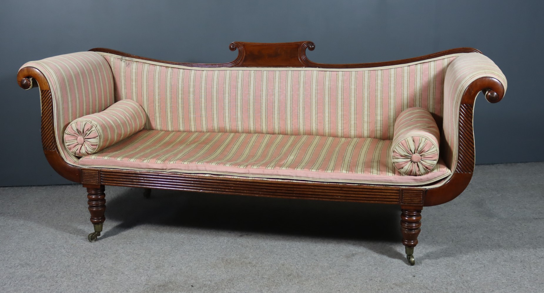 An Early Victorian Mahogany Scroll End Settee, with reeded frame, rectangular panel and scroll